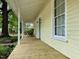 Inviting front porch with a porch swing, rocking chair, decorative columns, and a vibrant blue front door at 501 N Greensboro St, Carrboro, NC 27510