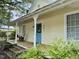 Inviting front porch with a porch swing, rocking chair, decorative columns, and a vibrant blue front door at 501 N Greensboro St, Carrboro, NC 27510