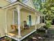 Inviting front porch with a porch swing, rocking chair, decorative columns, and a vibrant blue front door at 501 N Greensboro St, Carrboro, NC 27510