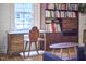 Cozy room features a unique wooden desk, bookshelf, and a view to the outside at 501 N Greensboro St, Carrboro, NC 27510