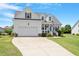 Beautiful two-story home with a well-manicured lawn, a front porch, and an attached two-car garage at 518 Spruce Meadows Ln, Willow Springs, NC 27592