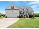 Charming home featuring a manicured lawn, a welcoming front porch, and an attached two-car garage at 518 Spruce Meadows Ln, Willow Springs, NC 27592