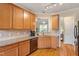Bright kitchen with stainless steel appliances and hardwood floors offers an adjacent view to living room at 518 Spruce Meadows Ln, Willow Springs, NC 27592