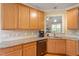 Well-lit kitchen features stainless steel sink, granite countertops and backsplash, with a view into the living room at 518 Spruce Meadows Ln, Willow Springs, NC 27592