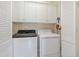 Bright laundry room equipped with washer, dryer and white storage cabinets at 518 Spruce Meadows Ln, Willow Springs, NC 27592
