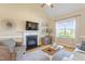 Bright living room boasts a fireplace, large window, and hardwood floors, creating a cozy and inviting atmosphere at 518 Spruce Meadows Ln, Willow Springs, NC 27592
