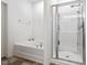 Spa-like bathroom features a separate tub and shower with glass doors, creating a serene retreat at 57 S Great White Way, Clayton, NC 27527