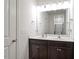 Bathroom vanity featuring double sinks, modern lighting, and dark wood cabinets for a luxurious feel at 57 S Great White Way, Clayton, NC 27527