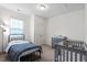 This bedroom includes a crib, a twin bed and a changing table at 57 S Great White Way, Clayton, NC 27527