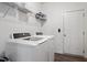Well-organized laundry room features a new washer and dryer, storage shelves, and a conveniently located door at 57 S Great White Way, Clayton, NC 27527