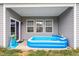 Covered patio featuring an inflatable pool, windows, and a sliding glass door for outdoor enjoyment at 57 S Great White Way, Clayton, NC 27527
