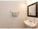 Powder room with pedestal sink, decorative mirror, and towel rack at 5742 Corbon Crest Ln, Raleigh, NC 27612