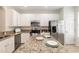 Bright kitchen with granite countertops, stainless steel appliances, and white cabinets at 5742 Corbon Crest Ln, Raleigh, NC 27612