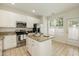 Bright kitchen with an island, stainless steel appliances, and a door to the exterior at 5742 Corbon Crest Ln, Raleigh, NC 27612