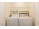 Efficient laundry room with a white washer and dryer set and wire shelving for storage at 5742 Corbon Crest Ln, Raleigh, NC 27612