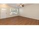 Open living area with wood-look flooring, ceiling fan, and large window for natural light at 5742 Corbon Crest Ln, Raleigh, NC 27612