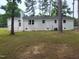 Rear exterior of the white brick home with several windows and a door at 623 Glenwood Dr, Sanford, NC 27330