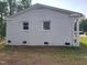 Side exterior showing the white brick facade with simple windows and landscaping at 623 Glenwood Dr, Sanford, NC 27330