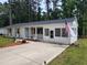 Front exterior of a white brick home with a screened porch and an American flag at 623 Glenwood Dr, Sanford, NC 27330