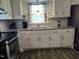 Kitchen with granite countertops, white cabinets, stainless steel oven, and a window at 623 Glenwood Dr, Sanford, NC 27330