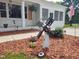 Detailed landscaping featuring mulch beds, a windmill, and various decorative elements at 623 Glenwood Dr, Sanford, NC 27330