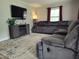 Living room with plush gray sectional, modern entertainment center and a large window at 623 Glenwood Dr, Sanford, NC 27330