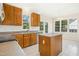 Bright kitchen with wood cabinets, an island, and a view of the backyard at 6521 Cablewood Dr, Raleigh, NC 27603