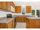 Well-lit kitchen featuring wood cabinetry and stainless steel appliances at 6521 Cablewood Dr, Raleigh, NC 27603