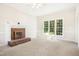 Bright living room featuring a red brick fireplace and large window at 6521 Cablewood Dr, Raleigh, NC 27603
