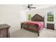 Spacious main bedroom with a decorative bed frame, ceiling fan, and natural light from the windows at 6521 Cablewood Dr, Raleigh, NC 27603