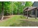 Spacious backyard with a patio, screened porch, lush lawn, and mature trees at 677 Juliette Ct, Creedmoor, NC 27522