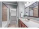 Bathroom featuring a bathtub with tiled walls, walk-in closet, and a vanity with a framed mirror at 677 Juliette Ct, Creedmoor, NC 27522