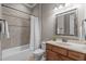 Bright bathroom featuring a shower-tub combo with tiled walls, vanity with mirror, and neutral color palette at 677 Juliette Ct, Creedmoor, NC 27522