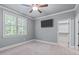 This bedroom features a ceiling fan, large window, and an open closet with ample natural light at 677 Juliette Ct, Creedmoor, NC 27522