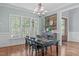 Bright dining room featuring modern chandelier, natural light from large windows, and hardwood floors at 677 Juliette Ct, Creedmoor, NC 27522