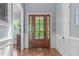 Inviting foyer featuring a decorative wood door with sidelights, hardwood floors, and classic wainscoting at 677 Juliette Ct, Creedmoor, NC 27522
