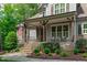 Charming front porch with stone steps, rustic beams, and ample seating space perfect for relaxing at 677 Juliette Ct, Creedmoor, NC 27522