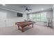 This game room has a beautiful billiard table and large windows for lots of natural light at 677 Juliette Ct, Creedmoor, NC 27522