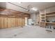 Spacious garage featuring custom wood accent wall, shelving, and ample storage at 677 Juliette Ct, Creedmoor, NC 27522