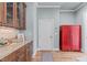 Hallway with hardwood floors features a built-in bar area and a bright red storage cabinet at 677 Juliette Ct, Creedmoor, NC 27522