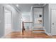 Upstairs hallway with hardwood floors, and railing leads to various rooms and a view of the billiard room at 677 Juliette Ct, Creedmoor, NC 27522