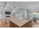 Kitchen with granite island, pendant lights, and a view into the living and dining areas at 677 Juliette Ct, Creedmoor, NC 27522