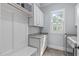 Well-organized laundry room features ample cabinet space, granite countertops, and a window for natural light at 677 Juliette Ct, Creedmoor, NC 27522
