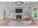 Bright living room features a coffered ceiling, fireplace, built-ins, and a large window at 677 Juliette Ct, Creedmoor, NC 27522