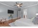 Large main bedroom with tray ceiling, hardwood floors, and view to the en-suite bathroom at 677 Juliette Ct, Creedmoor, NC 27522