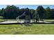 Community playground with slides, climbing structure, picnic table and swing set at 677 Juliette Ct, Creedmoor, NC 27522
