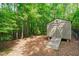 Outdoor storage shed with double doors and ramp access nestled among trees at 677 Juliette Ct, Creedmoor, NC 27522