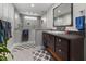 Luxurious bathroom featuring dual sink vanity, and a glass shower with bench and towel racks at 711 Hinsdale St, Raleigh, NC 27605