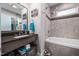 Modern bathroom with tiled tub and shower, granite countertop, and sleek fixtures at 711 Hinsdale St, Raleigh, NC 27605