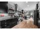 Modern kitchen features sleek, dark cabinetry, stainless steel appliances, and light hardwood floors at 711 Hinsdale St, Raleigh, NC 27605